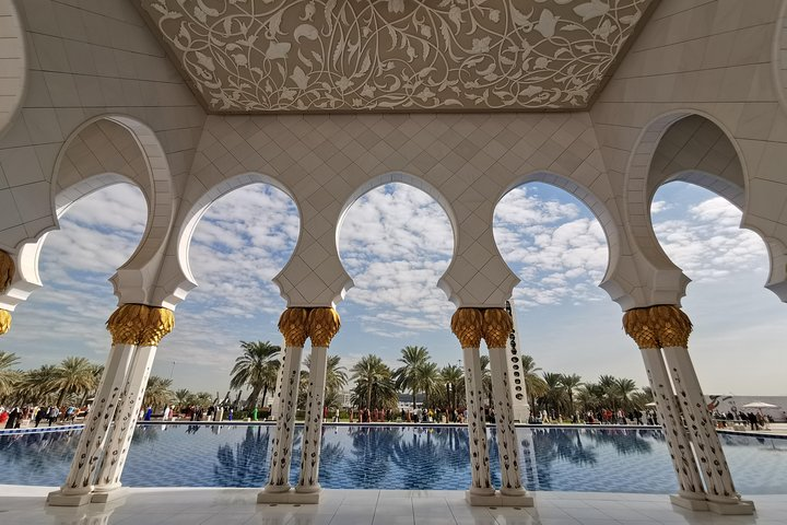 Experience the stunning blend of tradition and modernity with intricate architecture framing serene reflections promising unforgettable moments while exploring Abu Dhabi's rich heritage and art at the Louvre.